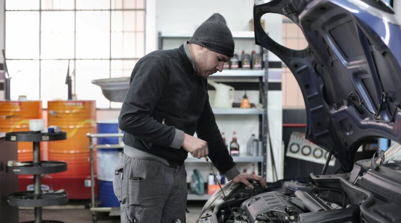 photo of man inspecting car engine