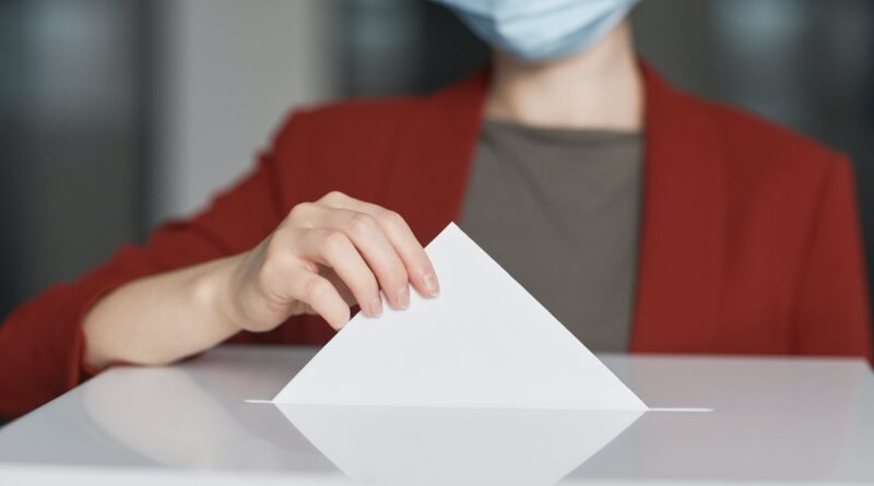 ballot box with person casting a vote